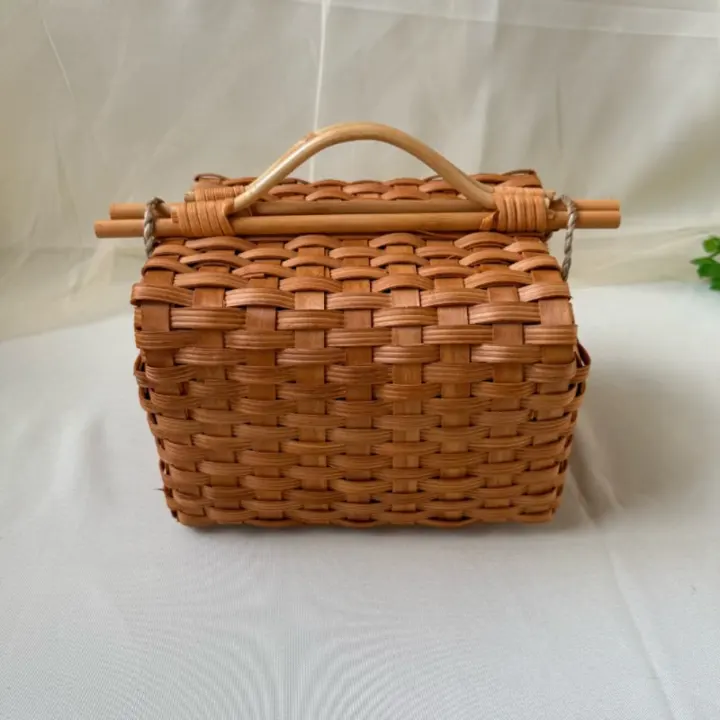 Flat-Woven Rectangular Carry Basket — Compact rectangular basket woven with broad flat strips, finished with an arched handle and crossbar closure.