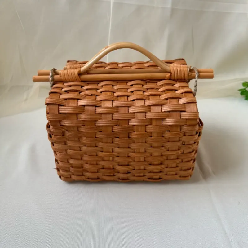 Flat-Woven Rectangular Carry Basket — Compact rectangular basket woven with broad flat strips, finished with an arched handle and crossbar closure.